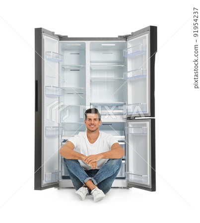 Man near open empty refrigerator on white background 91954237