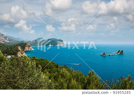 Picturesque view on rocks on a sunny day from the sea. Budva riviera, Montenegro. Aerial view of Sveti Nikola, Budva island, Montenegro. Hawaii beach, umbrellas and bathers and crystal clear waters Picturesque view on rocks on a sunny day from the sea. Budva riviera, Montenegro. Aerial view of Sveti Nikola, Budva island, Montenegro. Hawaii beach, umbrellas and bathers and crystal clear waters 91955285