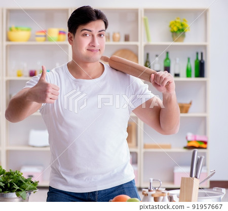 Young male cook working in the kitchen 91957667