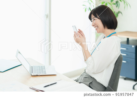 操作智能手機的辦公室工作人員 91957847