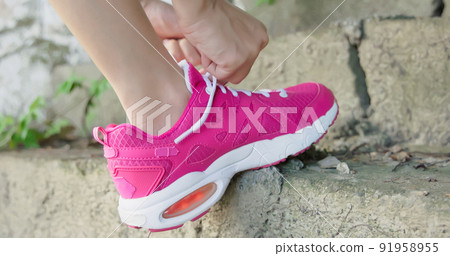 woman tie shoelaces while hiking woman tie shoelaces while hiking 91958955