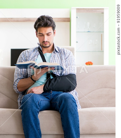 Young student man with hand injury sitting on the sofa 91959009