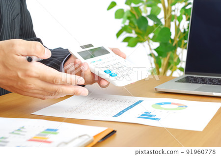 A man who shows and explains the numbers calculated with a calculator A man who shows and explains the numbers calculated with a calculator 91960778