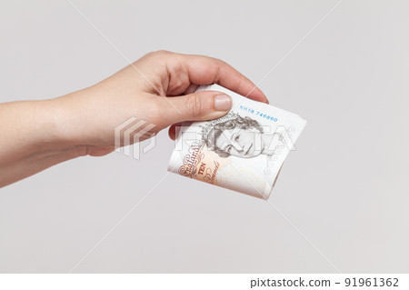 Stack of ten pound notes GBP in female hand 91961362