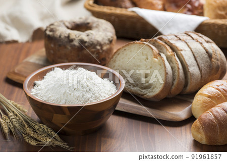 桌上排列著許多類型的麵包和麵粉 91961857