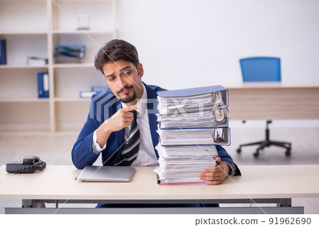 Young male employee and too much work in the office 91962690