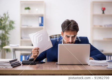 Young male employee unhappy with excessive work in the office 91962700