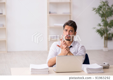 Young male employee unhappy with excessive work in the office 91963292