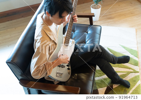 Young man playing electric bass Young man playing electric bass 91964713