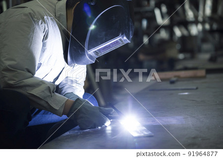 Welder image TIG welding Middle male worker who wears air-conditioning work clothes and welds 91964877