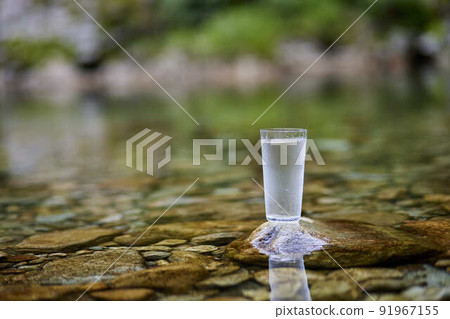 A glass of water placed in a beautiful river A glass of water placed in a beautiful river 91967155