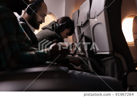 Diverse group of people travelling on commercial flight with international airways service. Flying with plane during sunset to arrive at airline destination, feeling scared about takeoff and flight. Diverse group of people travelling on commercial flight with international airways service. Flying with plane during sunset to arrive at airline destination, feeling scared about takeoff and flight. 91967264