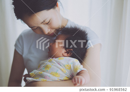 Mom who gently comforts a crying baby Mom who gently comforts a crying baby 91968562