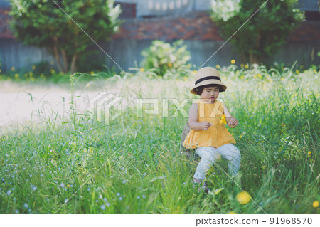 一個小孩在公園裡採花和玩耍 91968570