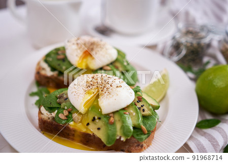 Freshly made poached egg and Avocado toasts on light grey background 91968714