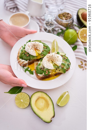 Freshly made poached egg and Avocado toasts on light grey background 91968716