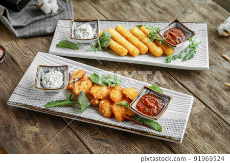Portion of fried appetizers with sauces 91969524