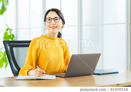 A woman using a laptop in a modern office 91970539