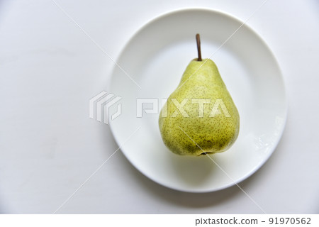 Green delicious pears on a white plate close-up Green delicious pears on a white plate close-up 91970562