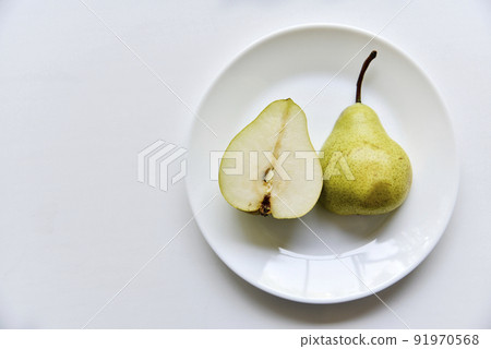 Green delicious pears on a white plate close-up 91970568