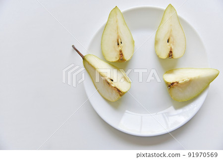 Green delicious pears on a white plate close-up 91970569