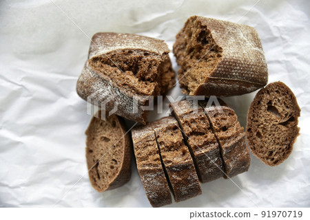 Rolls of rye black bread on white paper 91970719