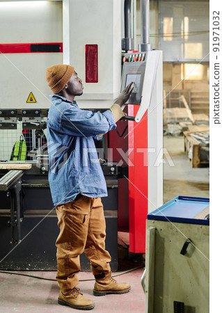 African young worker touching the monitor of computer machine to choose program before work African young worker touching the monitor of computer machine to choose program before work 91971032