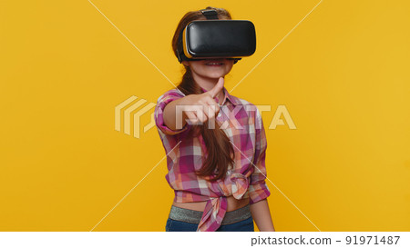 Child girl kid using virtual reality VR app headset to play simulation 3D video game watching video Child girl kid using virtual reality VR app headset to play simulation 3D video game watching video 91971487