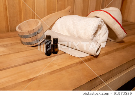 Traditional old Russian bathhouse SPA Concept. Interior details Finnish sauna steam room with traditional sauna accessories set basin towel aroma oil scoop felt. Relax country village bath concept 91973589