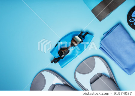 Set for training and learning to swim in the pool and open water on a blue background, top view with free space 91974087
