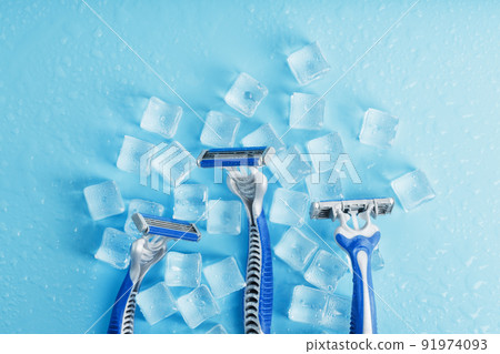 Three shaving machines on a frosty blue background with ice. The concept of cleanliness and frosty freshness Three shaving machines on a frosty blue background with ice. The concept of cleanliness and frosty freshness 91974093