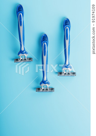 Blue shaving machines in a row on a blue background 91974109