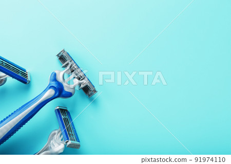 Blue shaving machines in a row on a blue background with ice cubes 91974110