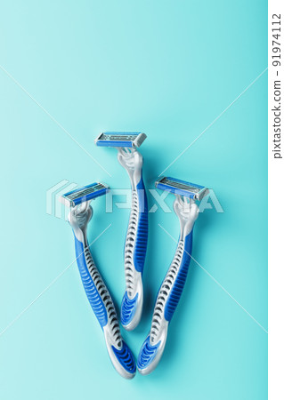 Blue shaving machines in a row on a blue background with ice cubes Blue shaving machines in a row on a blue background with ice cubes 91974112