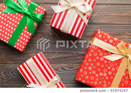 A lot of Christmas gift boxes in colored paper decorated on table, Top view close up. Many present New Year gift A lot of Christmas gift boxes in colored paper decorated on table, Top view close up. Many present New Year gift 91974247