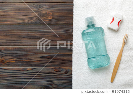 Mouthwash and other oral hygiene products on colored table top view with copy space. Flat lay. Dental hygiene. Oral care products and space for text on light background. concept 91974315