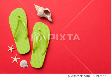 Flat lay composition with flip flops and seashell on colored background. Space for text top view Flat lay composition with flip flops and seashell on colored background. Space for text top view 91974530
