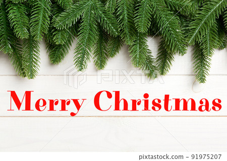 Merry Christmas text. Top view of fir tree on wooden background. Christmas concept with copy space 91975207