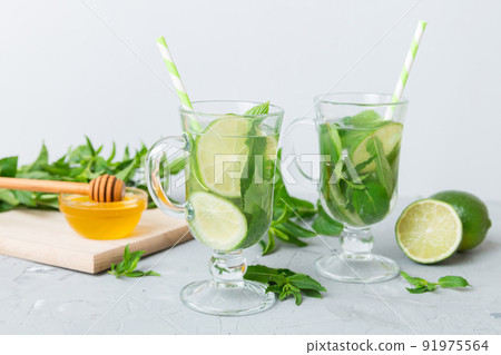 Mojito cocktail. Refreshing mojito cocktail with lime, lemon and mint in a tall glass with a stick Mojito cocktail. Refreshing mojito cocktail with lime, lemon and mint in a tall glass with a stick 91975564