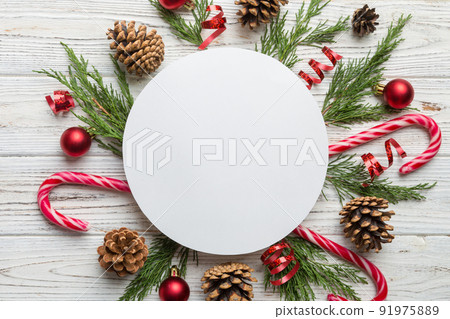 Flat lay Christmas composition. Round Paper blank, pine tree branches, christmas decorations on Colored background. Top view, copy space for text Flat lay Christmas composition. Round Paper blank, pine tree branches, christmas decorations on Colored background. Top view, copy space for text 91975889