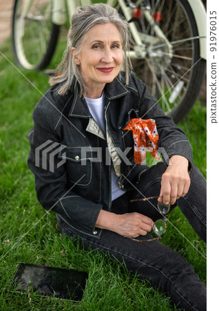 A good-looking woman in black resting near the river 91976015