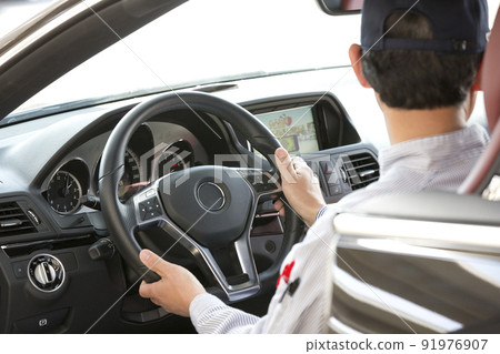 A man driving a car 91976907