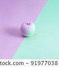 Multicolored wooden apple on a purple and green background. 91977038