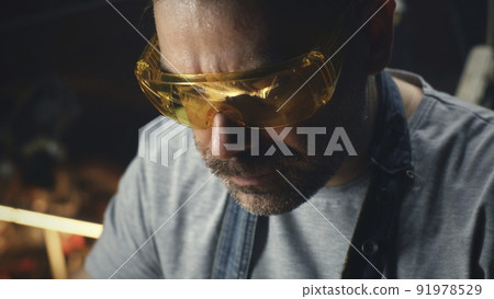 Man making a metal product in his garage Man making a metal product in his garage 91978529