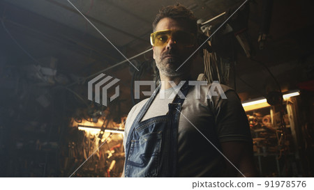 A man in garage looking at camera 91978576