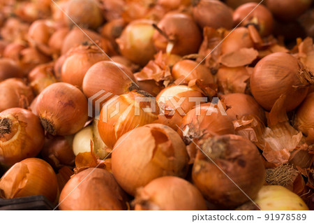 bulb onion in wicker baskets on market counter 91978589