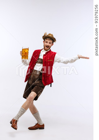 Portrait of Oktoberfest young emotional man in hat, wearing the traditional Bavarian clothes, holding beer mug. Alcohol, traditions, holidays, festival concept. Portrait of Oktoberfest young emotional man in hat, wearing the traditional Bavarian clothes, holding beer mug. Alcohol, traditions, holidays, festival concept. 91979256