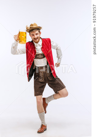 Portrait of Oktoberfest young emotional man in hat, wearing the traditional Bavarian clothes, holding beer mug. Alcohol, traditions, holidays, festival concept. Portrait of Oktoberfest young emotional man in hat, wearing the traditional Bavarian clothes, holding beer mug. Alcohol, traditions, holidays, festival concept. 91979257