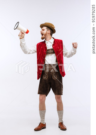 Excited man wearing traditional fest Bavarian or German outfit shouting at megaphone about Oktoberfest start. Party, holiday, ad,sales concept Excited man wearing traditional fest Bavarian or German outfit shouting at megaphone about Oktoberfest start. Party, holiday, ad,sales concept 91979285
