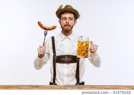 Portrait of Oktoberfest young emotional man in hat, wearing the traditional Bavarian clothes, holding beer mug. Alcohol, traditions, holidays, festival concept. Portrait of Oktoberfest young emotional man in hat, wearing the traditional Bavarian clothes, holding beer mug. Alcohol, traditions, holidays, festival concept. 91979288